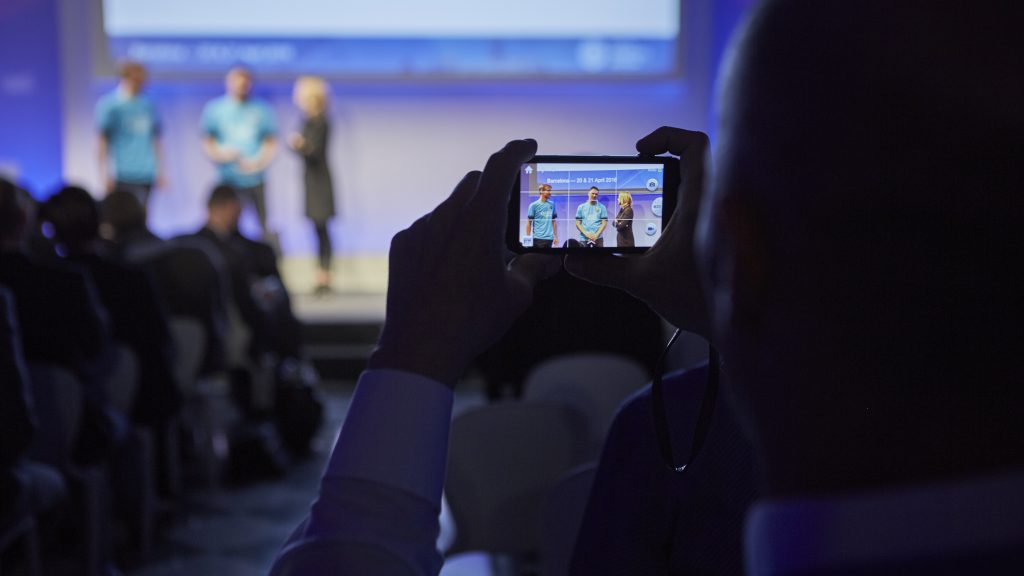 Attendee taking a photo of stage presentation at Digital Insurance Agenda (DIA) Barcelona 2016